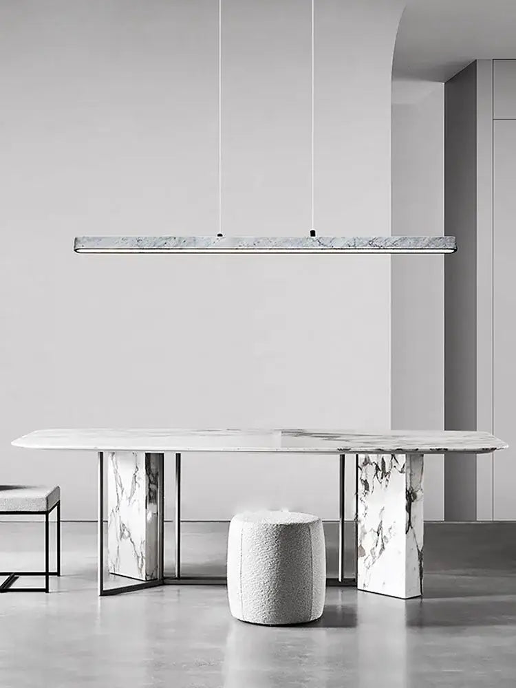 A sleek rectangular decorbites led natural marble hanging pendant light with white finish above a dining table
