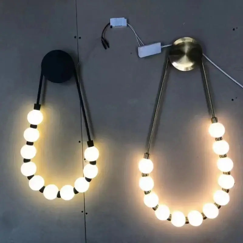 Modern wall lights featuring decorbites led necklace design with gold black metal and white acrylic spherical bulbs
