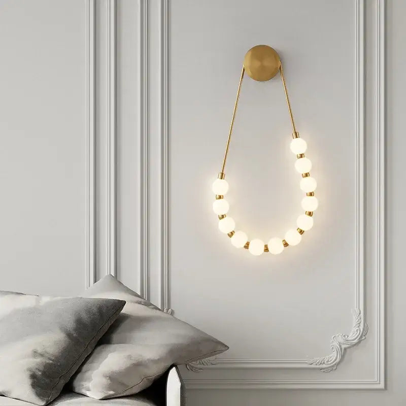 Gold-toned decorbites led necklace wall light with black metal base and glowing spherical led necklace wall bulbs for home use