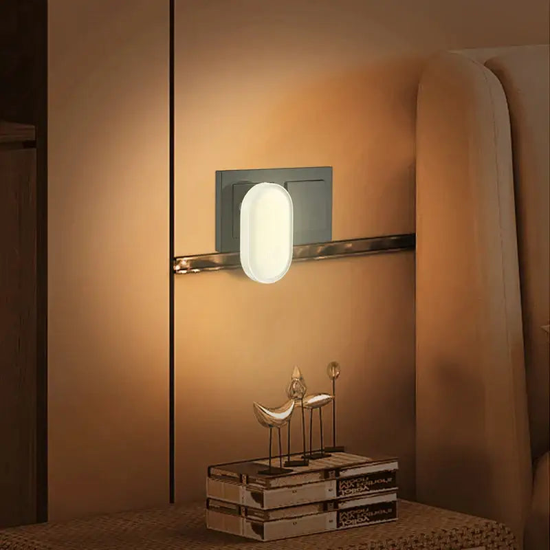 Modern oval-shaped decorbites led night light with soft white illumination and matte gray backplate for bedroom decor