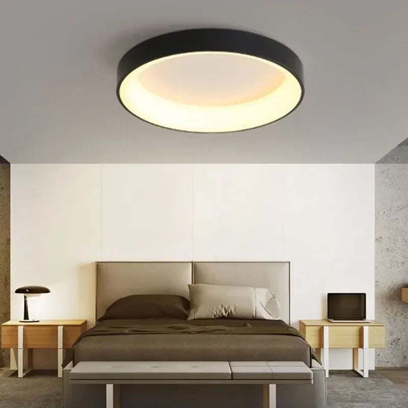 Black circular ceiling light with white interior, modern design.