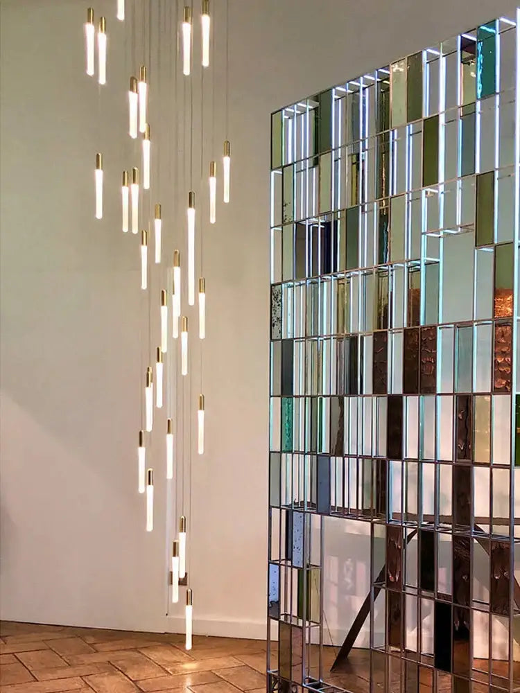 Modern pendant lights with slender glass tubes and gold caps in a cascading decorbites led nordic cylinder chandelier for indoor use
