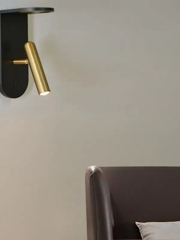 A sleek black and gold DecorBites LED Nordic wall lamp with a cylindrical brass head for wall atmosphere decoration