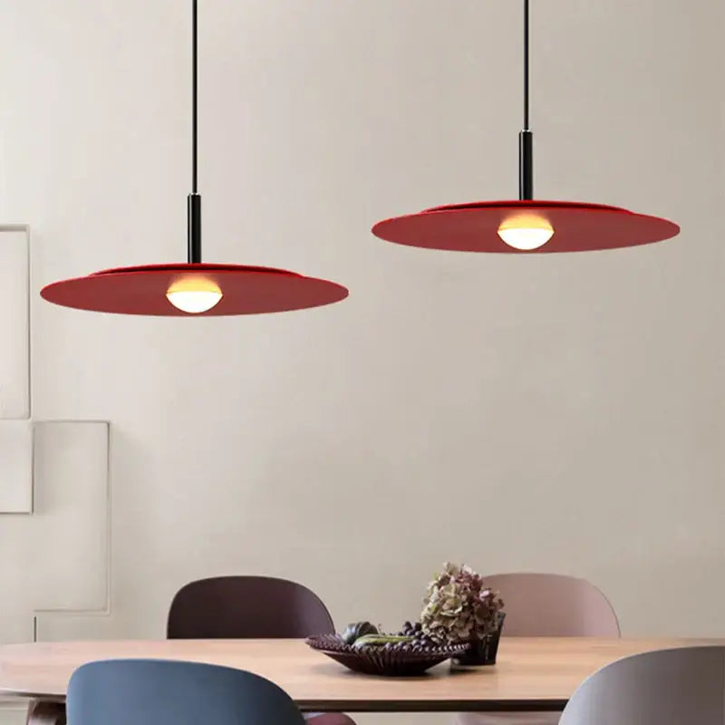 Two modern red led flying saucer chandelier pendant lights with sleek black cords and disc-shaped shades by decorbites