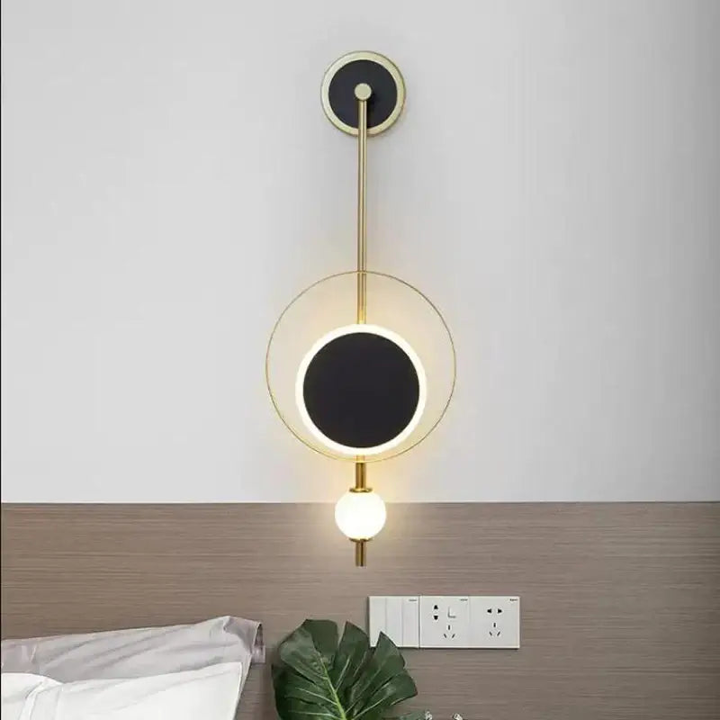 Modern gold-toned decorbites led nordic wall lights with circular black illuminated face and spherical bulb for indoor decor