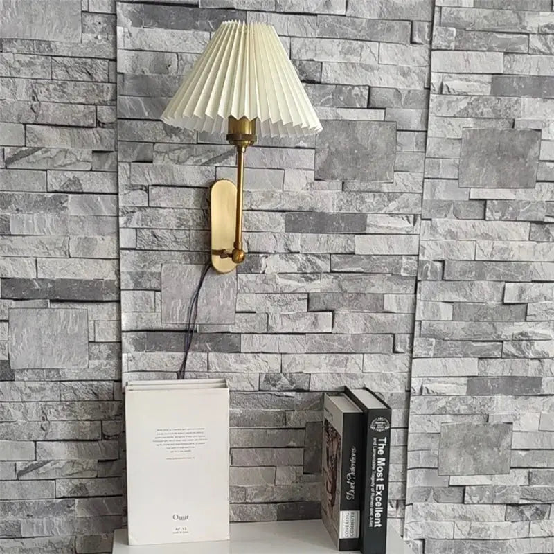 Cream-colored pleated lampshade on brass-finished decorbites led origami wall lamp for bedroom and living room lighting