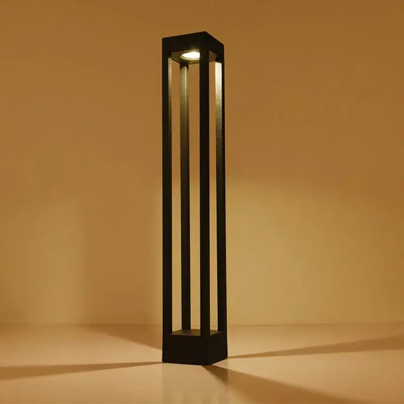 Black rectangular decorbites led outdoor lawn light with vertical slats and warm glowing top light for garden use
