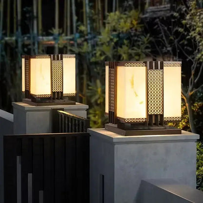 Warm-toned decorbites led outdoor marble street lamp with geometric metalwork and frosted glass on stone pedestals