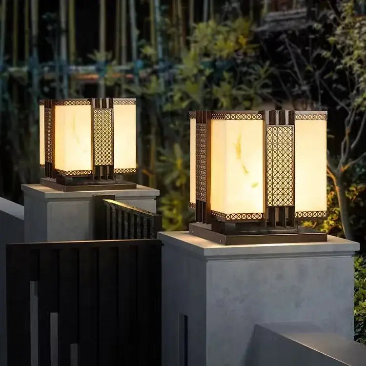 Warm-toned decorbites led outdoor marble street lamp with geometric metalwork and frosted glass on stone pedestals