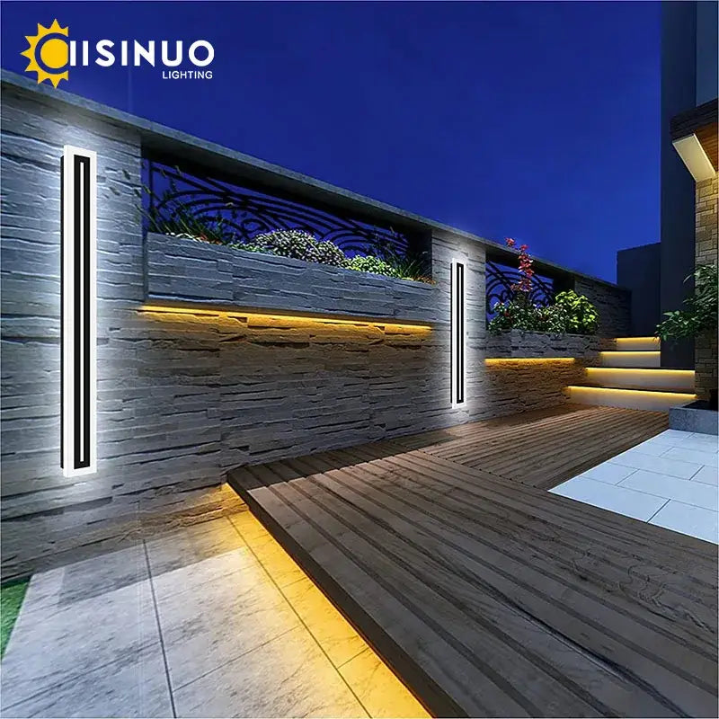 DecorBites™ LED outdoor wall lamp with slim black and white aluminum design emitting warm ambient light on stone walls
