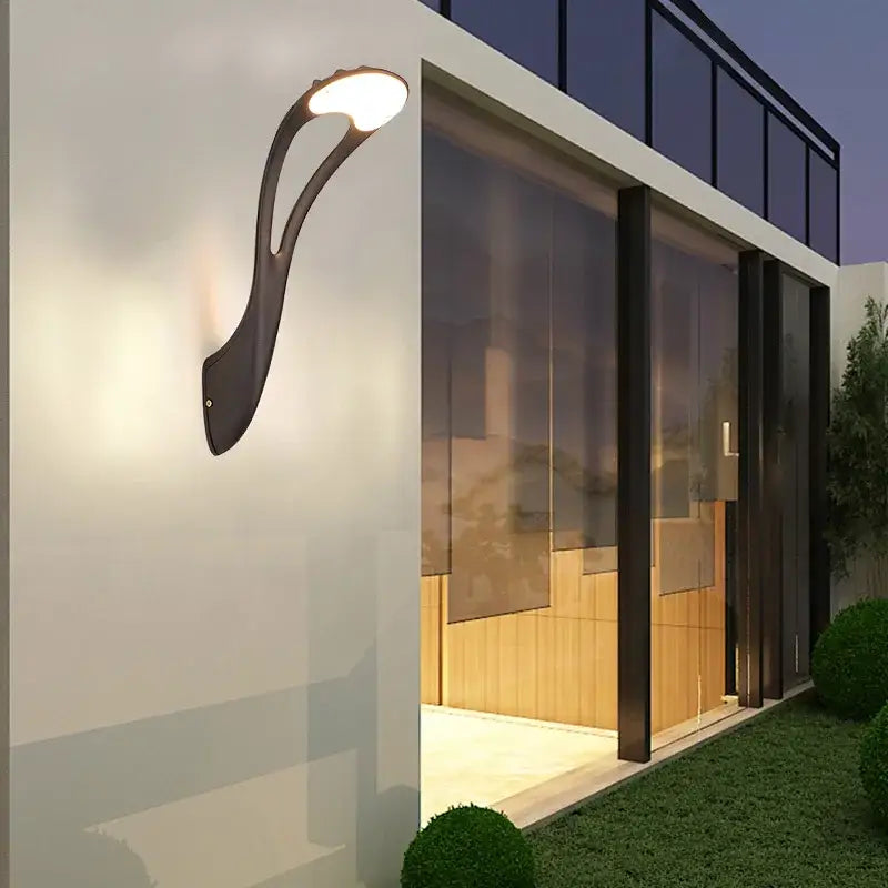Modern black DecorBites™ LED outdoor wall lamp with sleek curved design and warm white light for garden or balcony use