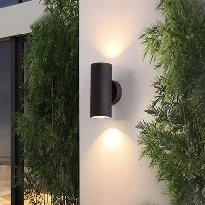 Black cylindrical decorbites™ led outdoor wall lamp with dual downward-facing lights for porch lighting