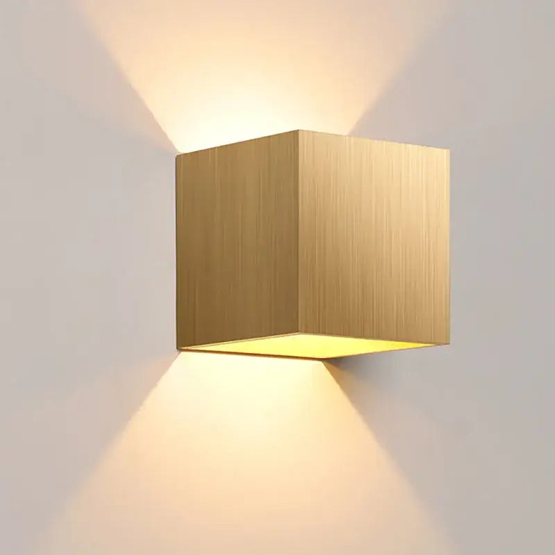 Modern gold-finished cube outdoor wall light with brushed metal texture and warm directional led lighting by decorbites