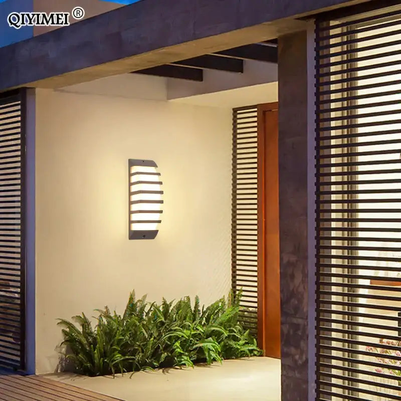 Modern black decorbites led outdoor wall sconce with horizontal slats emitting warm light for outdoor wall use