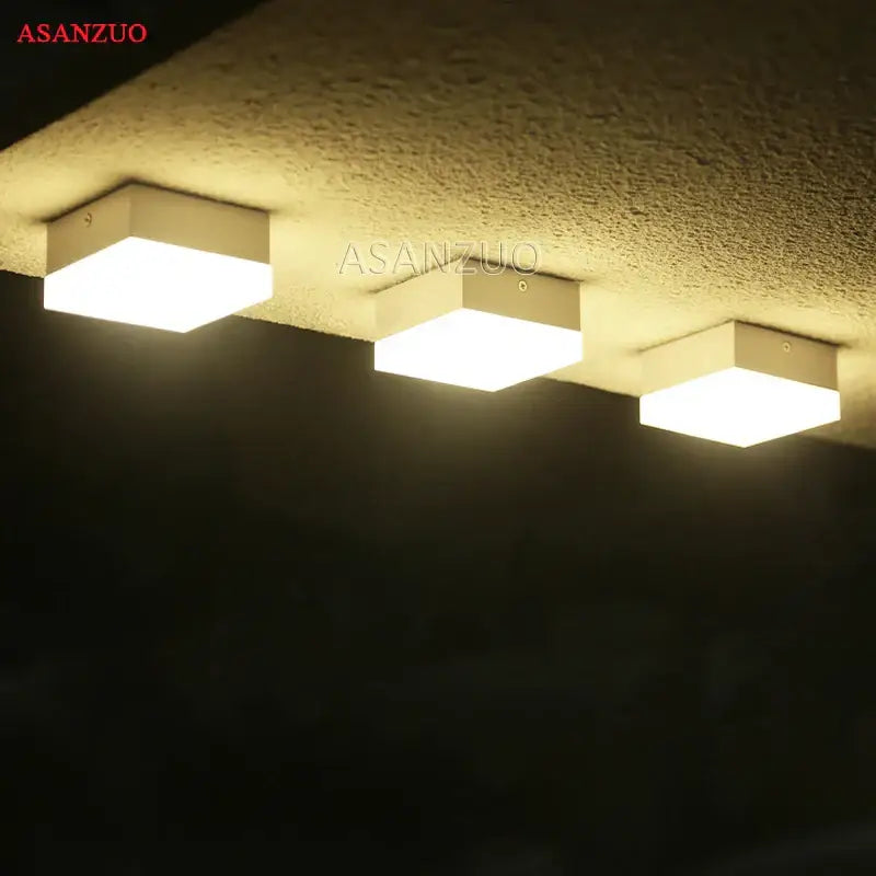 Three white decorbites led panel lights with sleek square design emit warm illumination for ceiling use