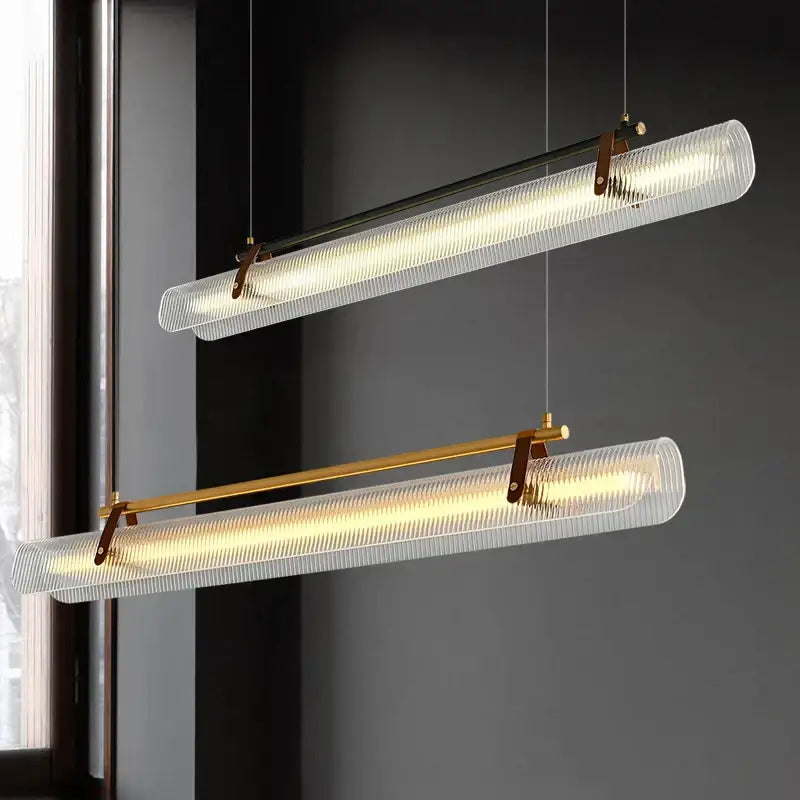 Two modern decorbites led pendant lamps with textured glass shades and brass accents for dining room lighting