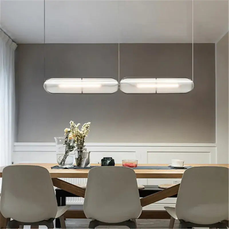 Modern minimalist decorbites led pendant lamp with frosted glass diffusers hangs above a dining table for warm lighting