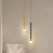 Two minimalist decorbites led pendant lights with gold and black finishes featuring sleek cylindrical bodies and warm globe bulbs