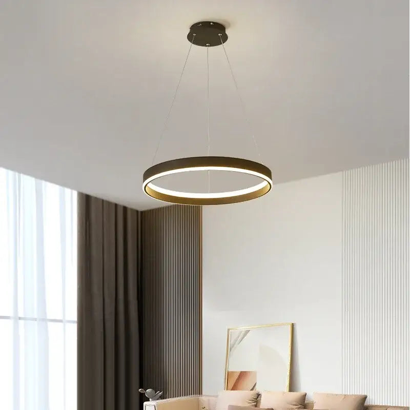 Modern decorbites led pendant lamp with a sleek black and gold frame emitting warm ambient light for bedroom and foyer