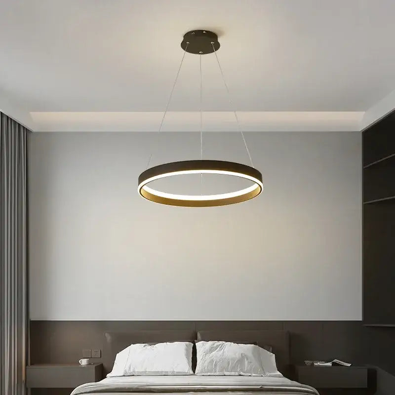 Modern decorbites led pendant lamp with black outer ring and gold inner rim emitting warm ambient light for home use