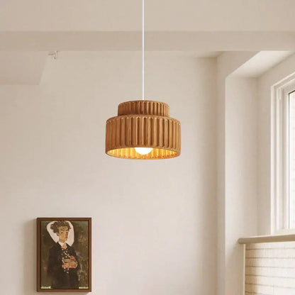 Warm-toned cream decorbites led pendant lamp with ribbed ceramic tiered design and soft golden glow