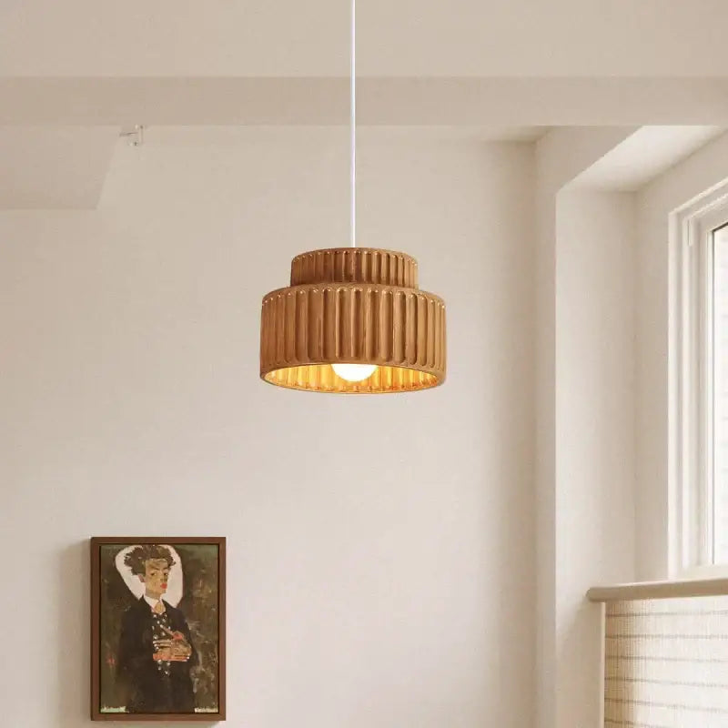 Warm-toned cream decorbites led pendant lamp with ribbed ceramic tiered design and soft golden glow