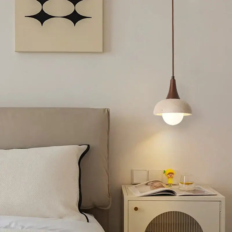 A decorbites led pendant lamp featuring a matte white glass dome shade and slender brown metal stem for bedside use