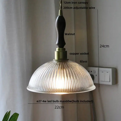 A warm-toned ribbed glass decorbites led pendant lamp with dark walnut iron canopy and adjustable brass knob switch