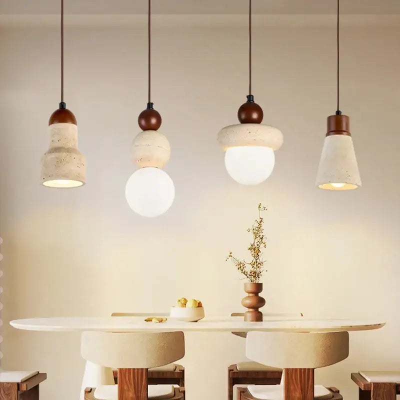 Four decorbites led pendant lamps with textured concrete shades and wood canopy hang above a minimalist dining table