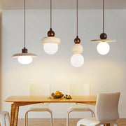 Four matte white concrete shade pendant lamps with dark brown accents hang above wood table decorbites led pendant