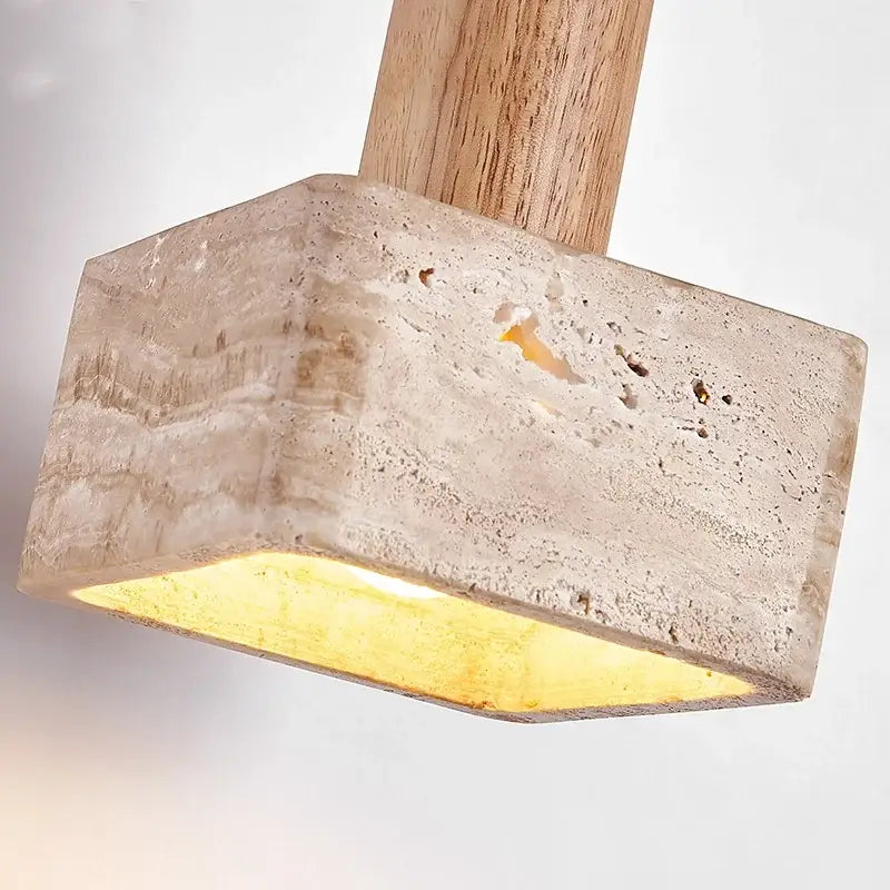 A rustic pendant light featuring yellow travertine stone with a wooden handle and warm glowing interior by decorbites
