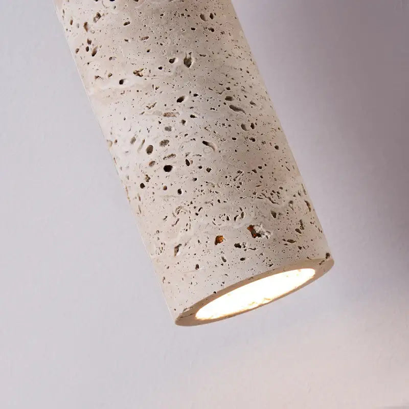Cylindrical decorbites led pendant lamp with speckled yellow travertine textured surface and illuminated bottom opening