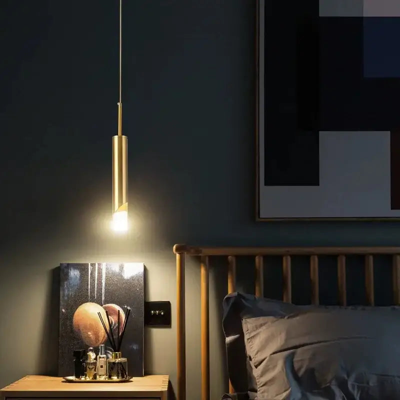 A sleek cylindrical gold decorbites led pendant lamp with warm glow made of acrylic for kitchen island lighting