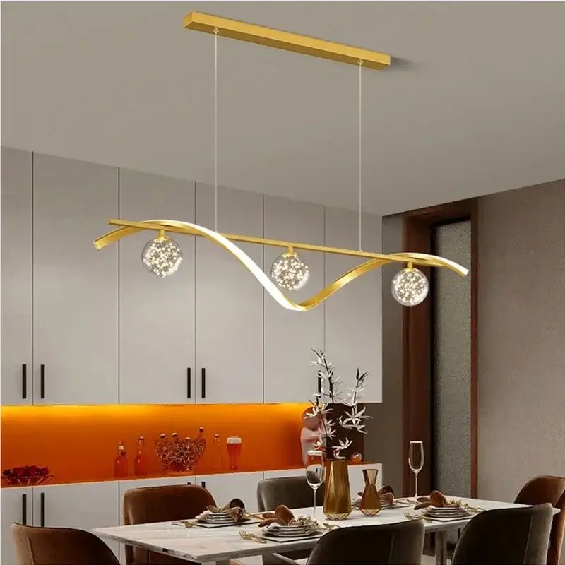 Gold-colored decorbites led pendant with sleek curved design and three crystal-encrusted bulbs for dining room lighting