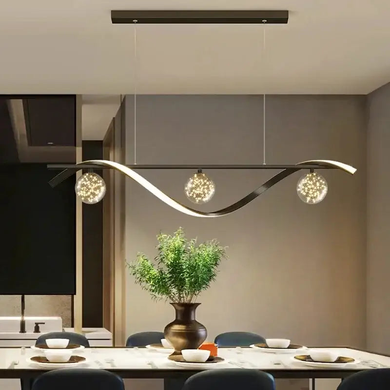 Modern black metal decorbites led pendant with three spherical glass globes emitting warm sparkling led light for dining room