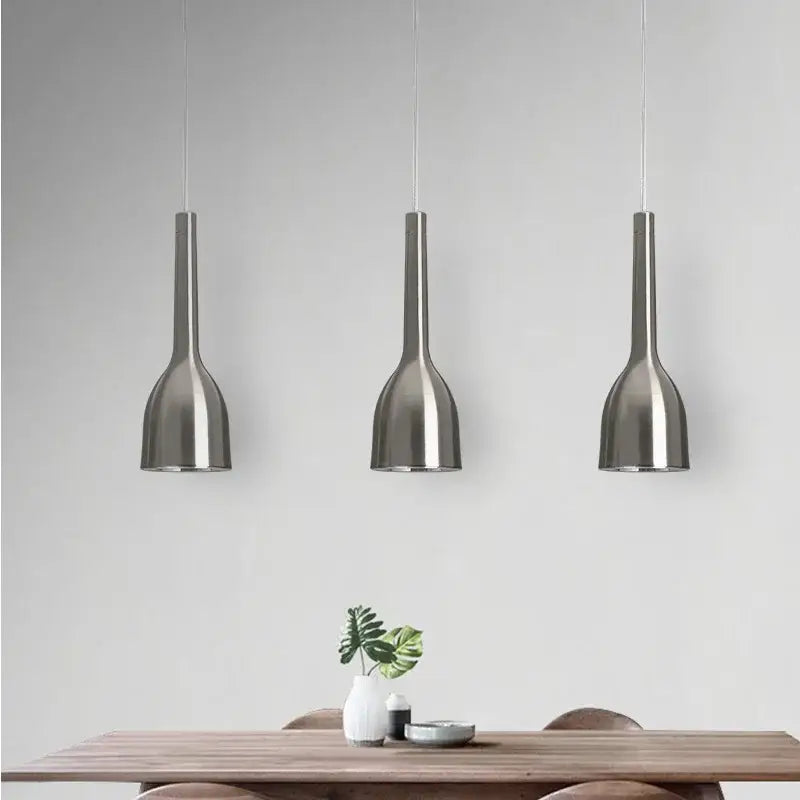 Three brushed nickel decorbites led pendant lights with modern bottle design hang symmetrically above dining table