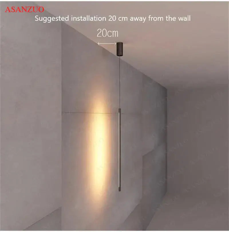 Minimalist black cylindrical pendant light with adjustable line strip and warm ambient glow for modern decor