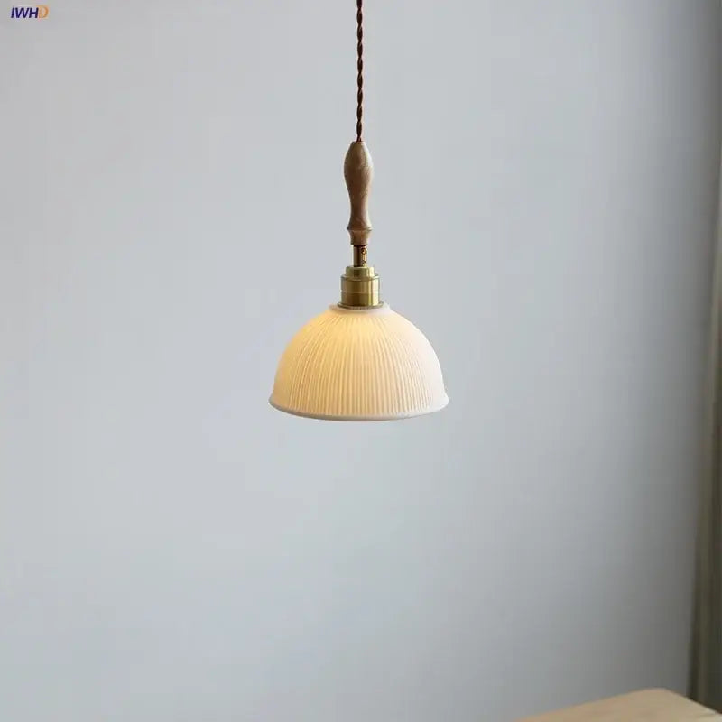 DecorBites led pendant light with warm-toned white ceramic shade, ribbed design, brass fixture, and ash wood handle