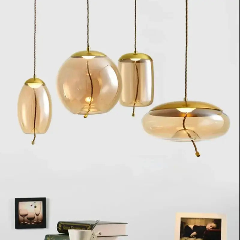 Set of modern amber glass pendant lights with gold metal accents and braided cords in DecorBites led pendant chandelier