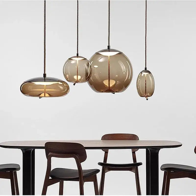 Set of modern amber glass pendant lights with sleek black cords and warm lighting decorbites led pendant chandelier