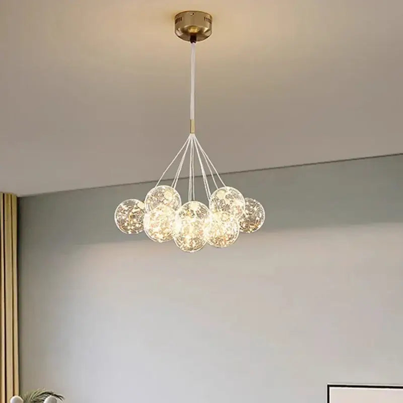 Modern brass-finished DecorBites LED pendant light with clear textured glass spheres for living and dining room decor