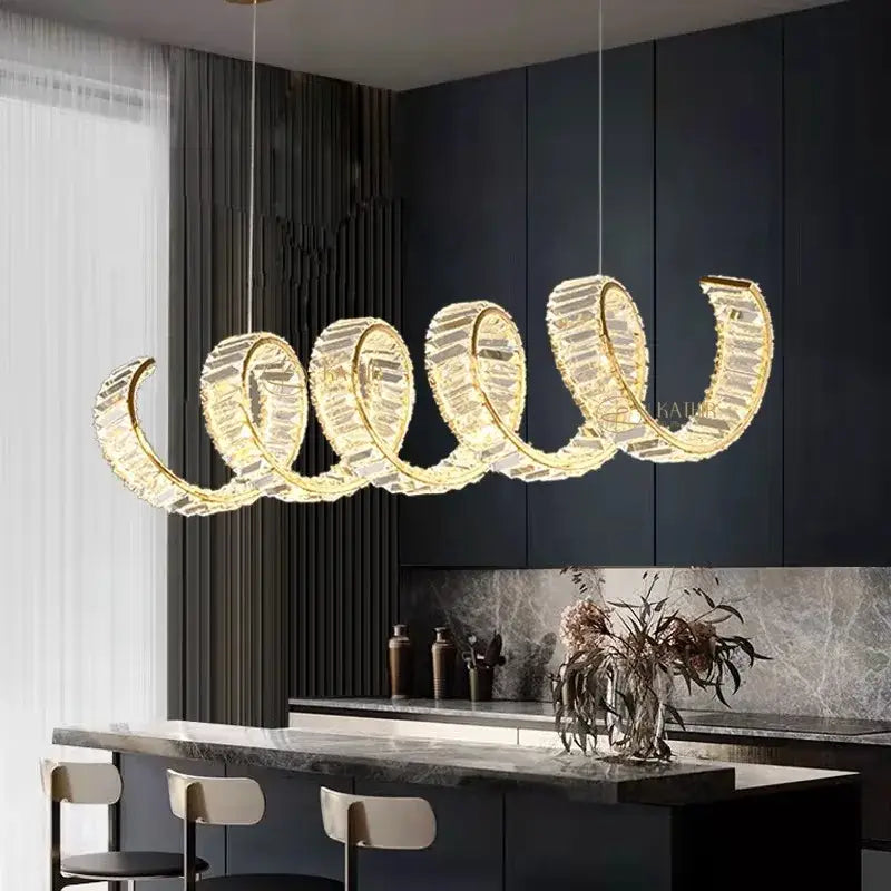 Golden spiral decorbites led pendant light chandelier with crystal accents hanging above modern kitchen island