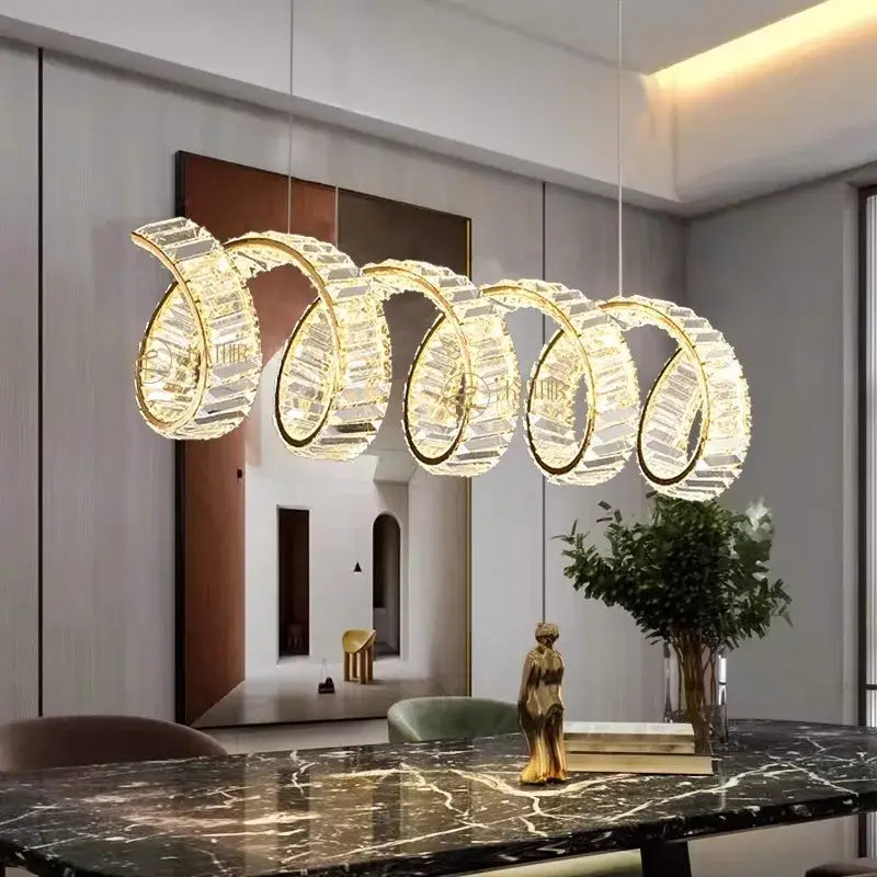 A modern gold-toned crystal DecorBites LED pendant light chandelier with five interlocking rings for living and dining rooms