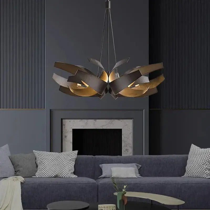 Modern bronze and gold-toned metal decorbites led pendant light chandelier with layered design over dark gray sofa