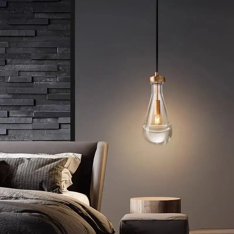 A DecorBites led pendant light with clear glass bulb brass accents and black cord for living room indoor lighting