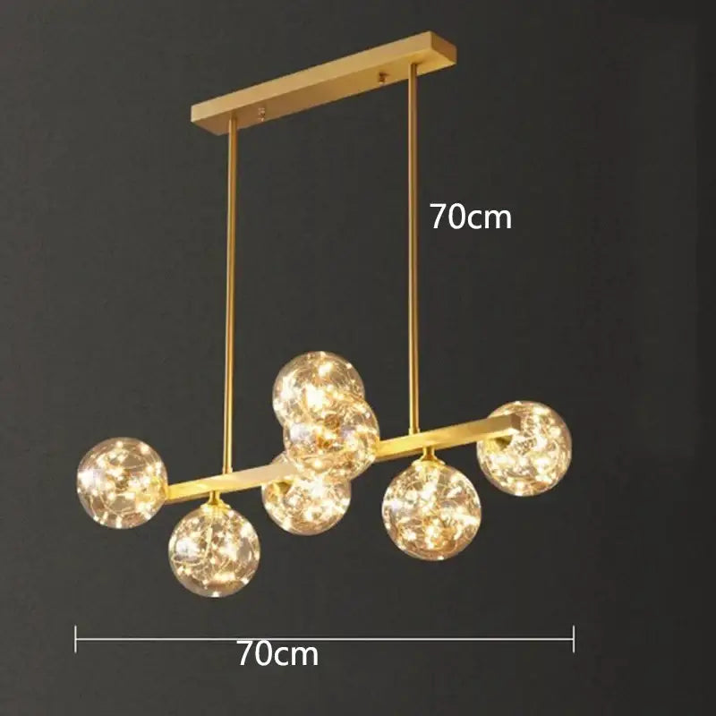 Gold-toned decorbites led pendant light chandelier with five spherical glass globes emitting warm light for modern decor