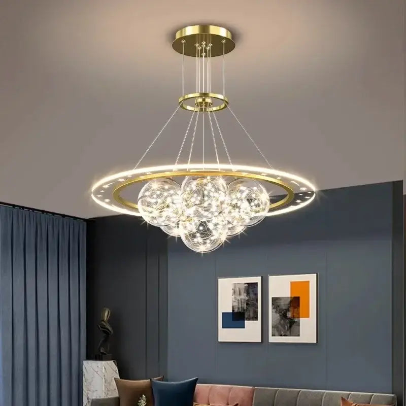 A modern gold-toned DecorBites led pendant light chandelier with circular frame and clear glass spheres for indoor lighting