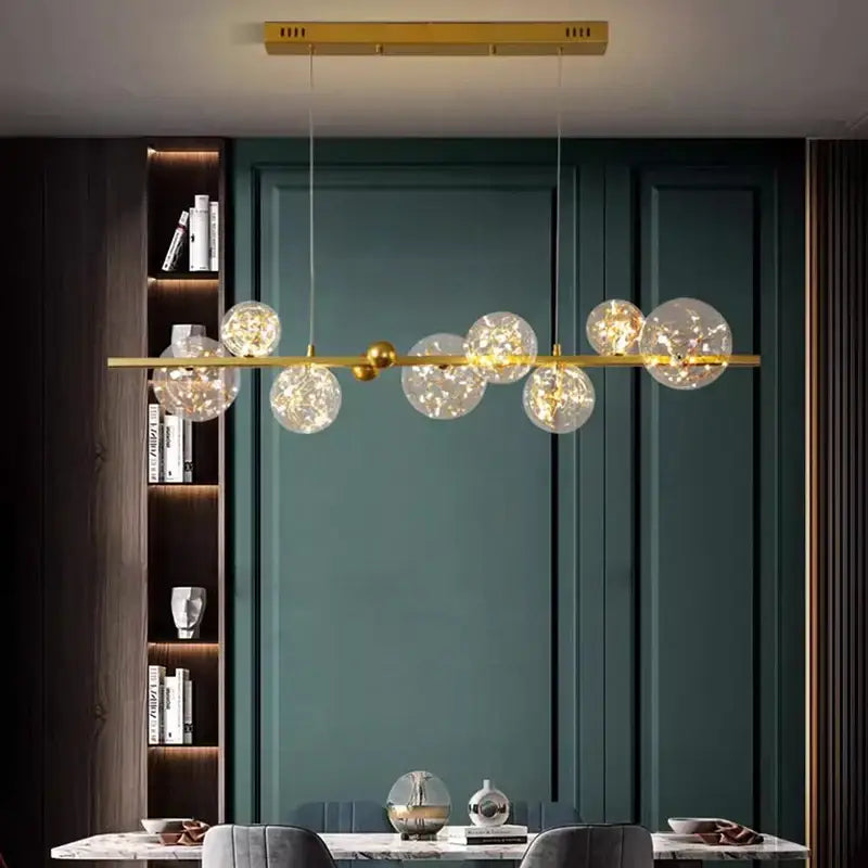 Gold-toned decorbites led pendant light chandeliers with clear glass spheres and warm glowing bulbs for indoor decor