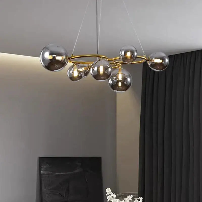 Modern gold-toned decorbites led pendant light chandelier with multiple reflective glass spheres for indoor lighting