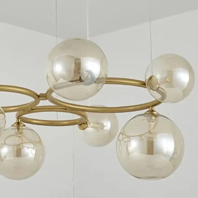 Gold-toned DecorBites LED pendant light chandelier with multiple spherical glass globes for modern indoor lighting